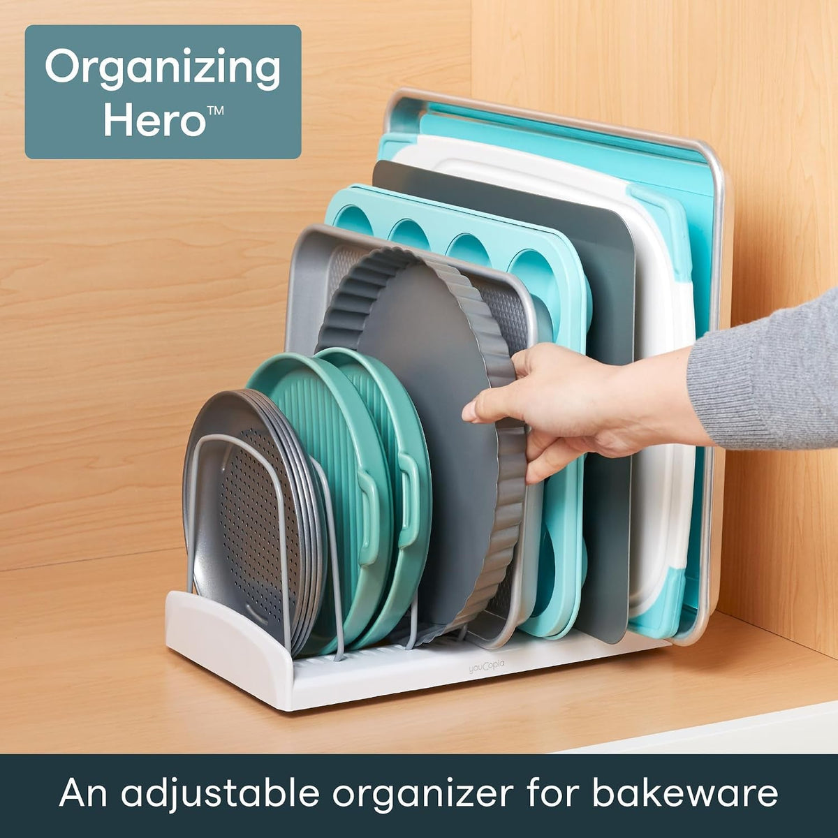 In a cupboard, holding baking trays, a tart tin and a muffin tray